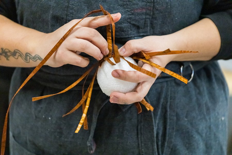 A woman's hands weaving cedar