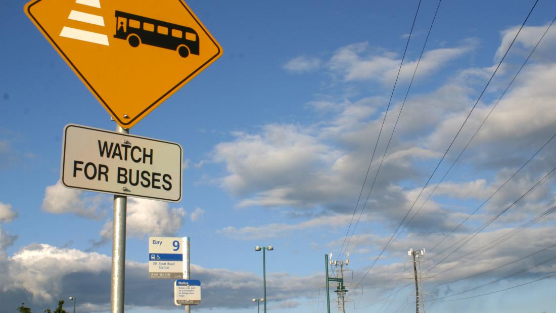 a sign for bus stops against blue sky