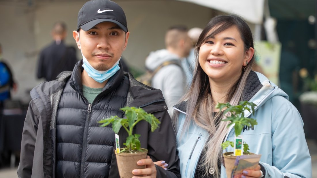 two people hold up plants