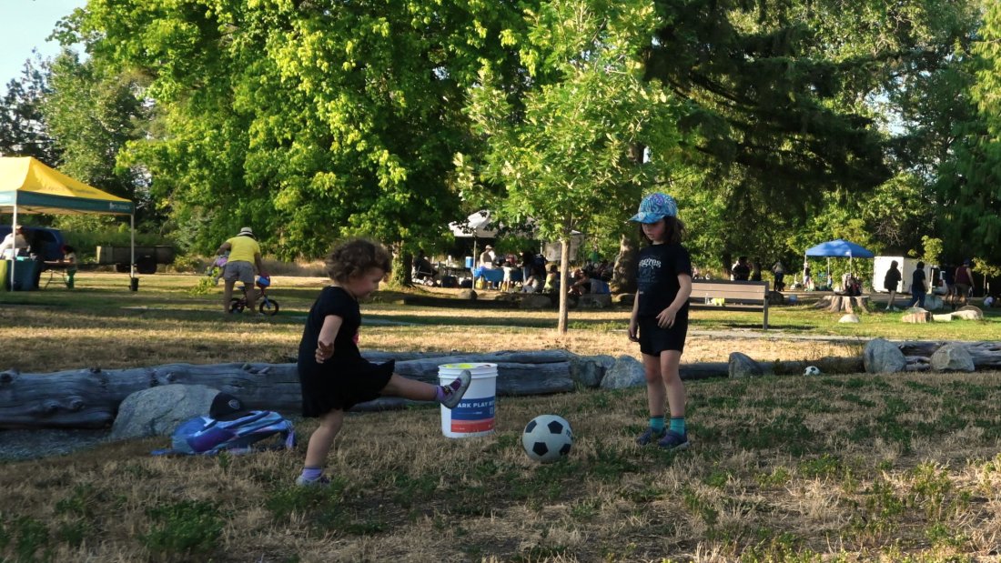 two children kick a soccer ball