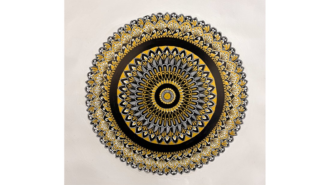 A mandala made with yellow and black ink. 