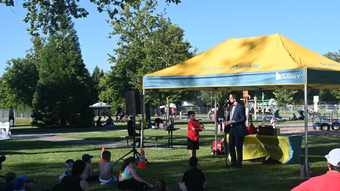 a magician performs a trick under a Surrey Parks tent