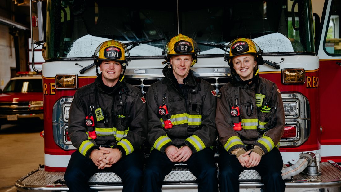 Firefighters sitting infront of firetruck