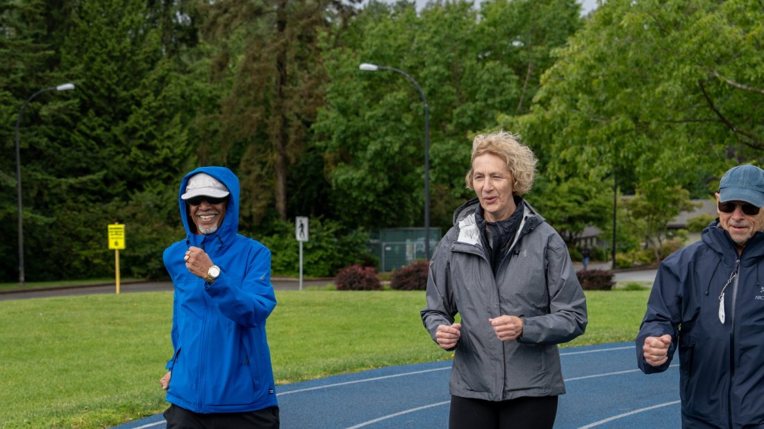 three older adults on an outdoor walking track