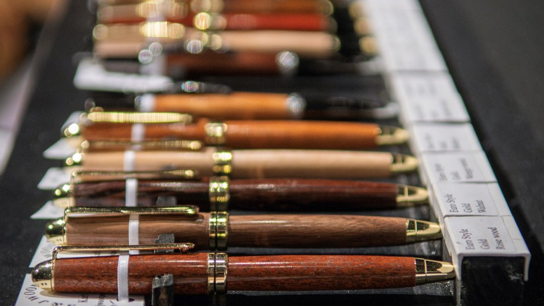 Wooden pens displayed lying down in a row.