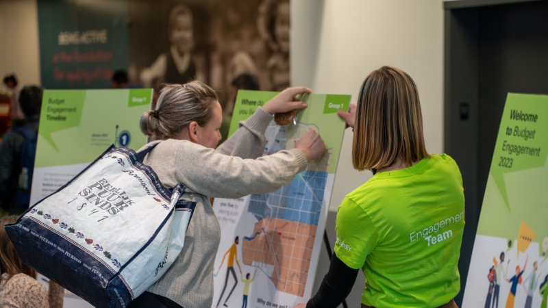 a woman pins a note to an engagement board