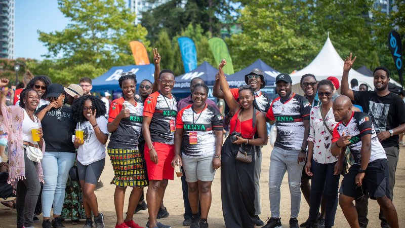 a group of black people pose for a photo at the kenyan pavillion in front of some tents