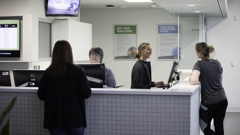 Four people at a front desk.