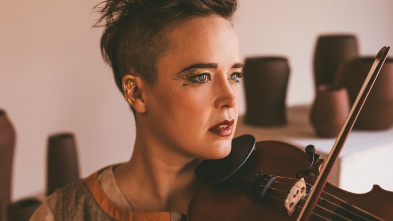 Close up of Raine Hamilton with a violin under their chin ready to play