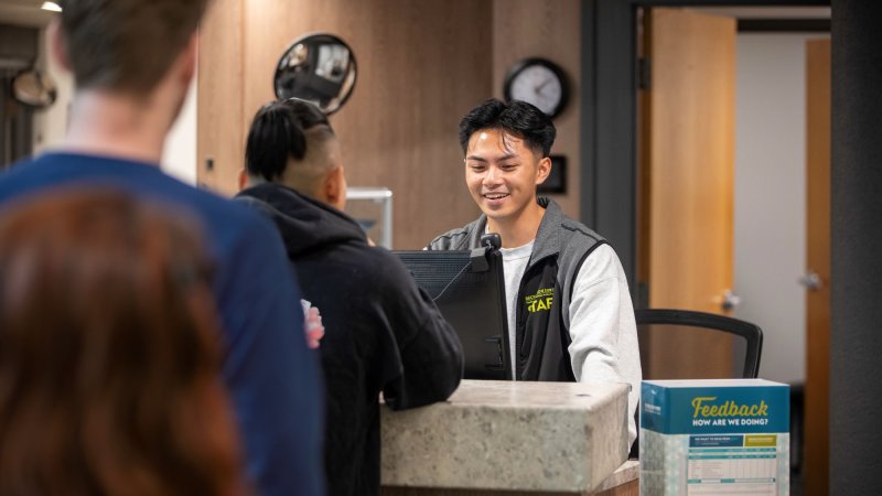 A staff member helping out a patron at the front desk.