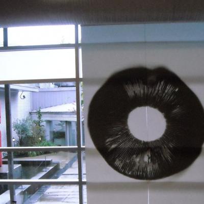 A black circular drawing in front of a window
