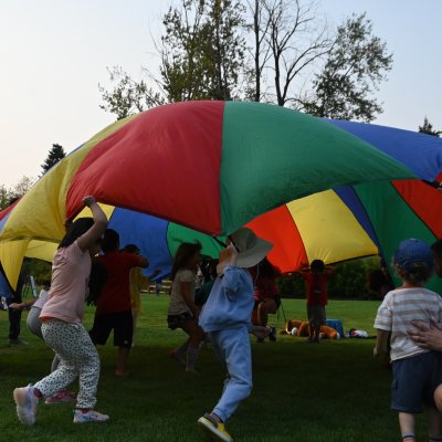 children run under a parachute