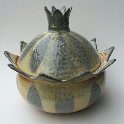 A ceramic bowl with pointed spikes and a lid