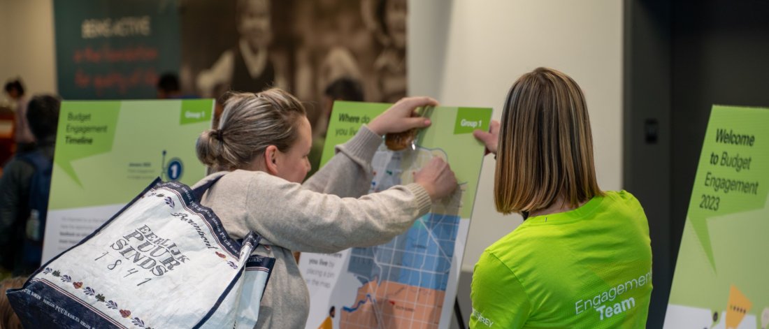 a woman pins a note to an engagement board