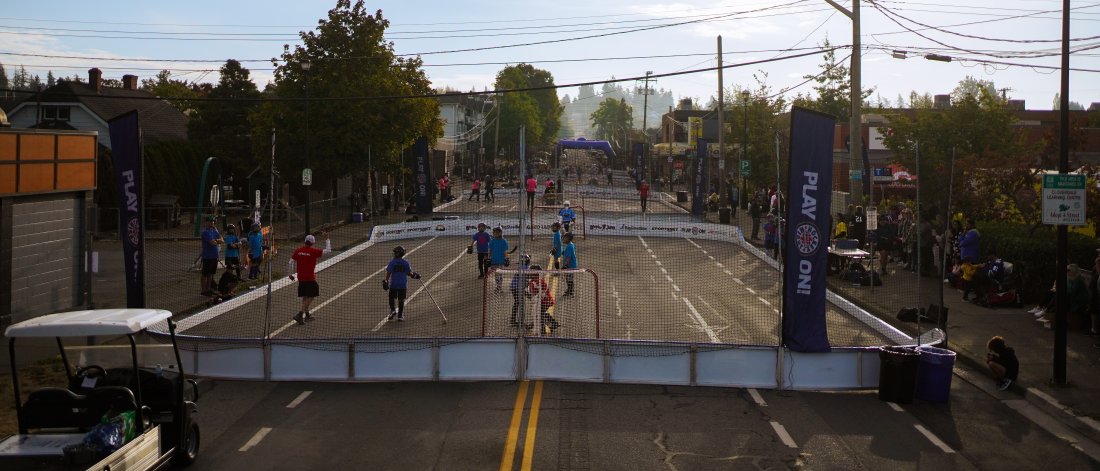 People playing street hockey arena on a closed road in downtown Cloverdale. 