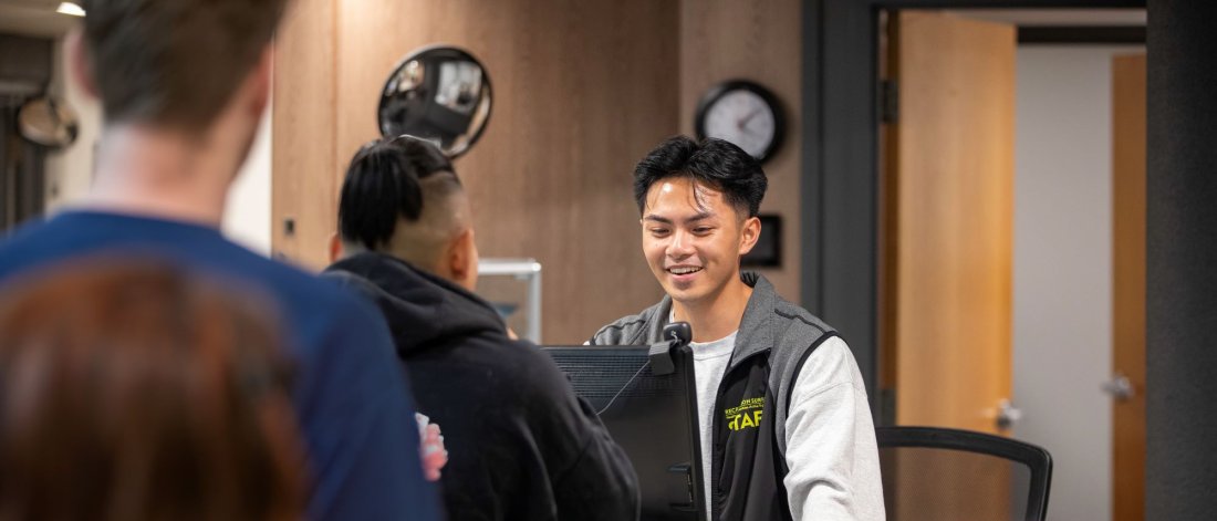 A staff member helping out a patron at the front desk.