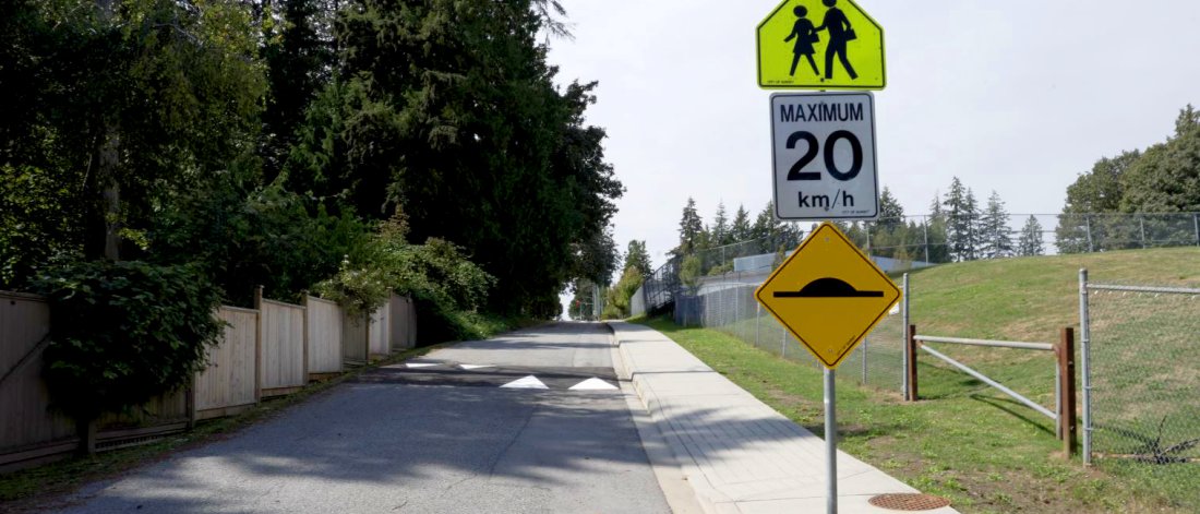 School zone road in Surrey with a 20 km/h speed limit sign and a speed hump