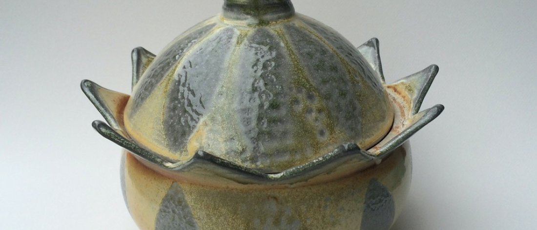 A ceramic bowl with pointed spikes and a lid