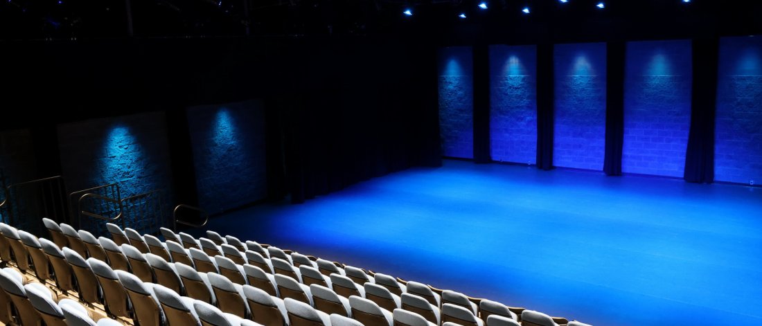 studio theatre at surrey arts centre with seating pulled out and blue lighting