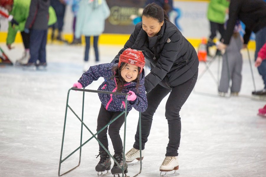 A mom and daughter ice skating.