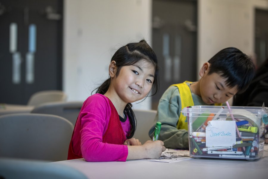 A girl smiling while making crafts.